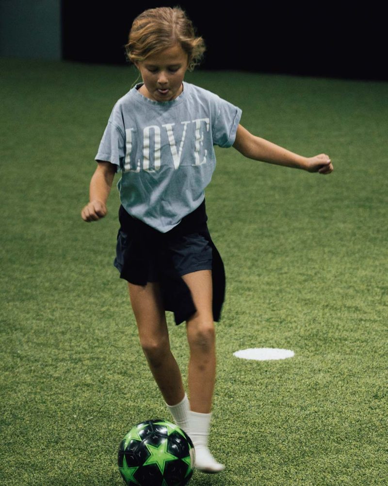 Youth soccer player dribbling during a summer camp at Prestige Indoor Sports in Overland Park