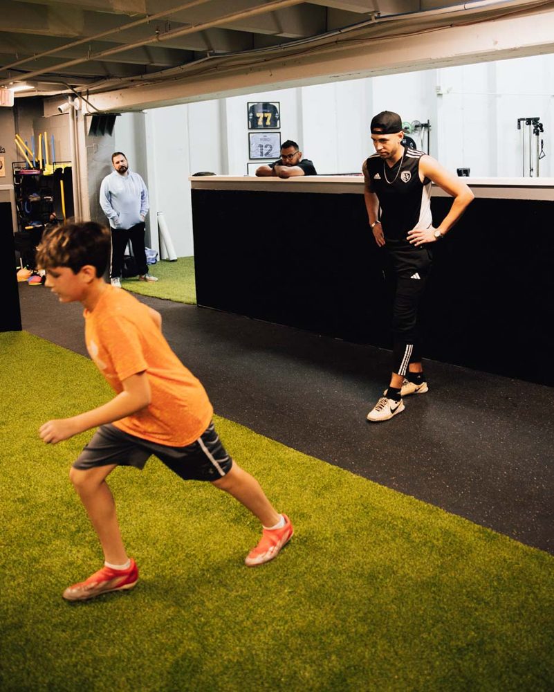 Young soccer player working through a controlled dribbling drill during indoor training